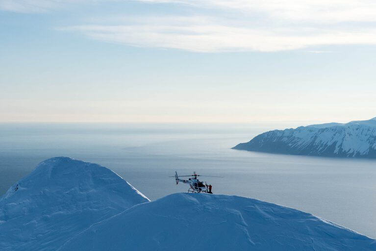 Private helicopter landing on mountain peak in Iceland