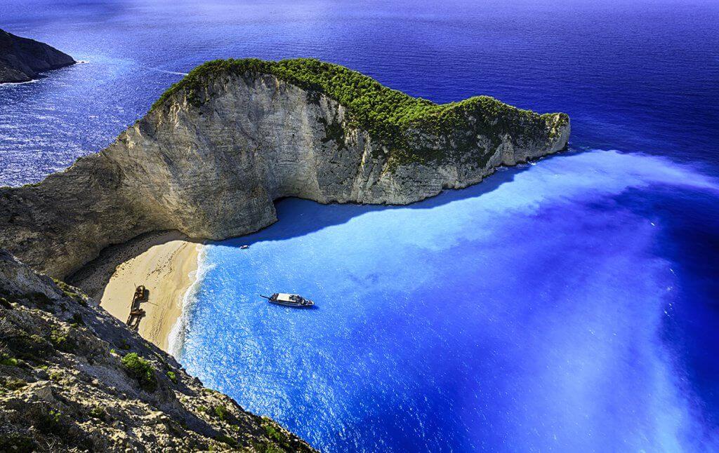 Aerial view of sandy cove and blue water at Navagio Beach on Zakynthos Island