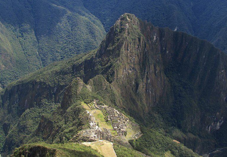 Aerial view of Machu Picchu ancient Incan ruins surrounded by green Andes mountains including Huayna Picchu