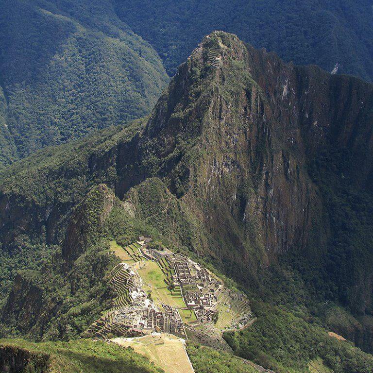 Aerial view of Machu Picchu ancient Incan ruins surrounded by green Andes mountains including Huayna Picchu