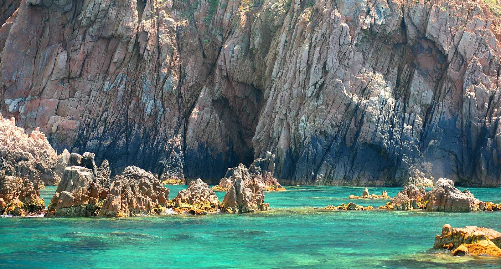 Turquoise water along the rocky cliffs in Scandola Nature Reserve in Corsica