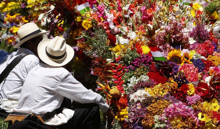 Silleteros in Medellin sitting in front of their flower arrangements