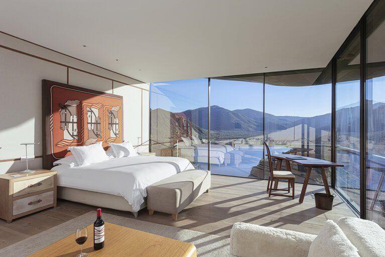 Luxury suite with floor to ceiling windows and a mountain view at Viña Vik hotel in Chile