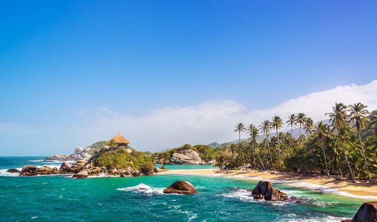 Isolated beach with turquoise water, white sand, and palm trees in Tayrona National Park