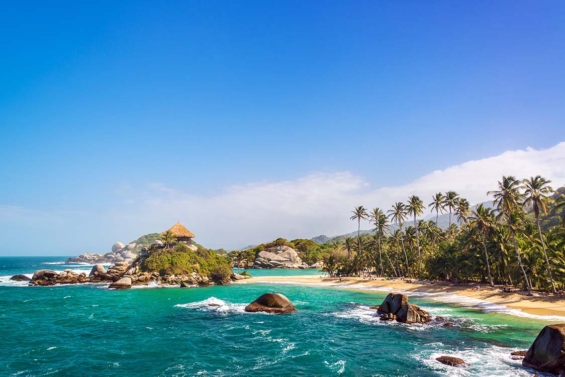 Isolated beach with turquoise water, white sand, and palm trees in Tayrona National Park