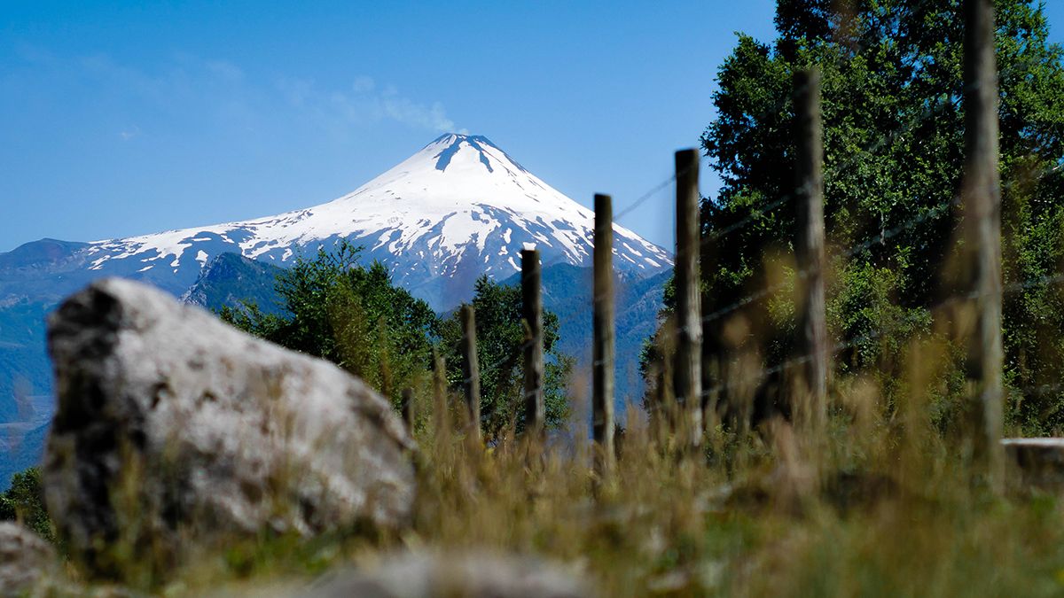 Snow capped Villarrica Volcano from behind a wooden fence in Pucon, Chile
