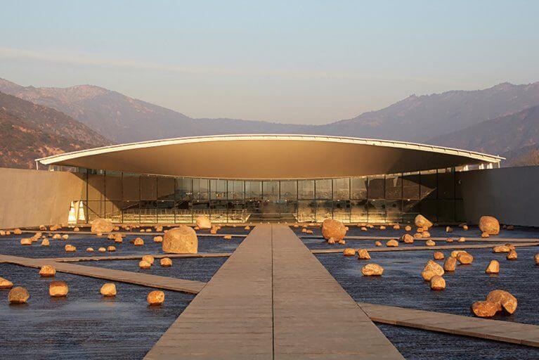 Sleek, modern, entrance of Viña Vik winery in Chile with the Andes mountains in the distance