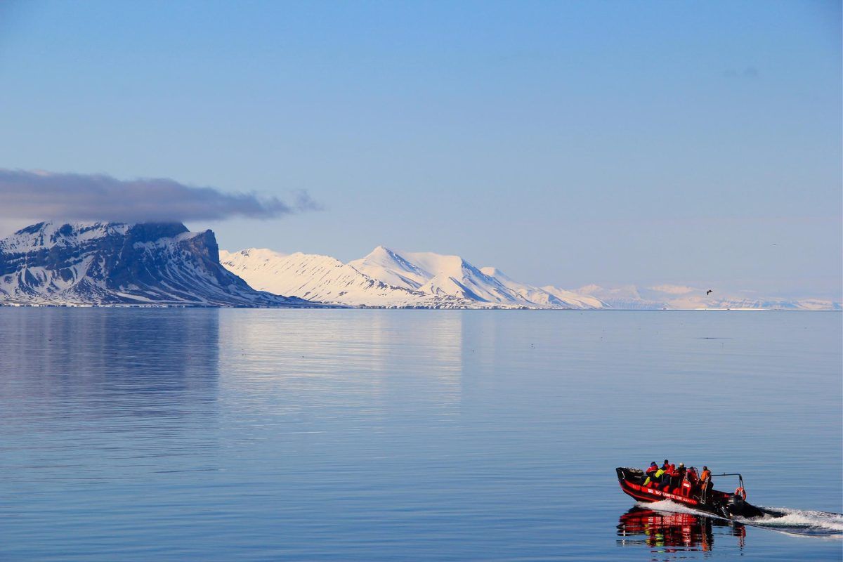 A zodiac boat sailing along the coast of Svalbard