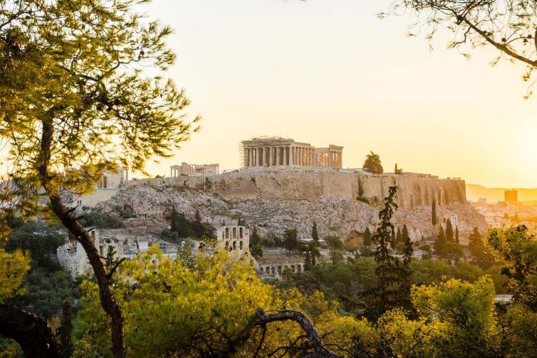 Ruins of the Acropolis from a distance at golden hour in Athens, Greece