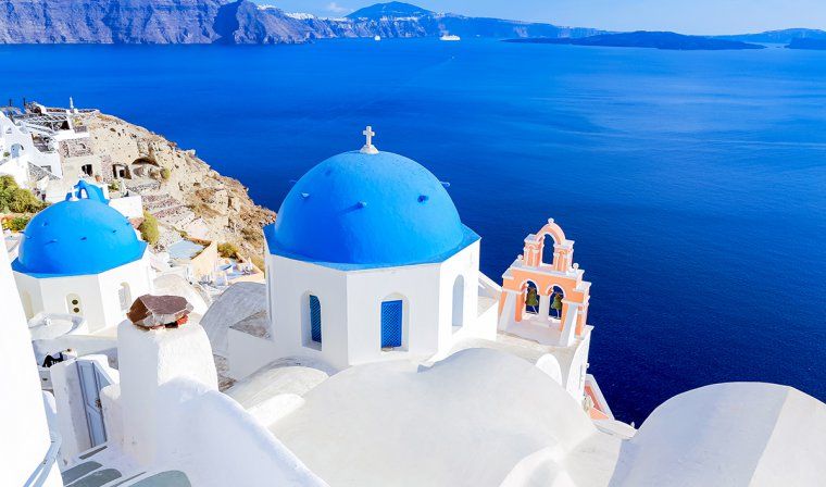 Blue domes of white churches overlooking Aegean sea in Santorini