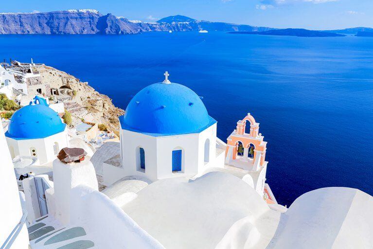 Blue domes of white churches overlooking Aegean sea in Santorini