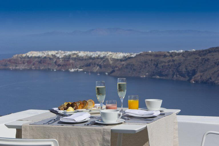 Breakfast on terrace overlooking Aegean sea at Grace luxury hotel in Santorini