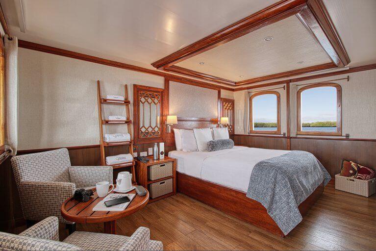 Master cabin with bed and reading area on luxury private yacht cruising in Galapagos Islands
