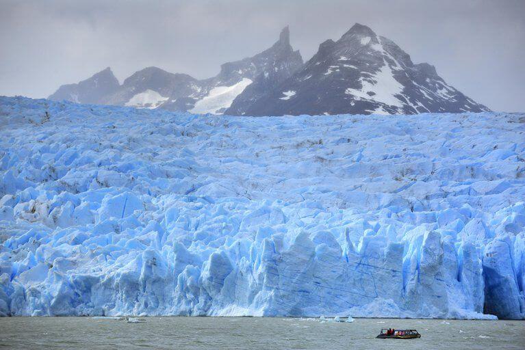 Blue Glacier Grey seen from the middle of Lake Grey with mountains in background