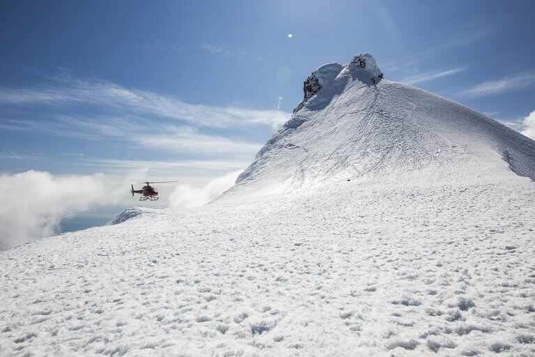 Helicopter landing on the snowy peak of Snaefellsjokull