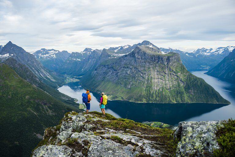 A couple admiring the view during a hiking excursion in the mountains above a fjord