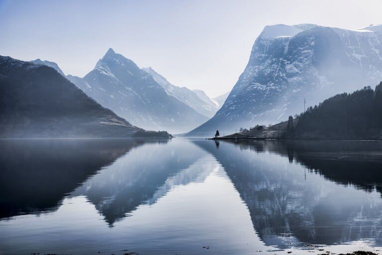 Landscape showing mountains reflected in the water of Hjørundfjord Fjord