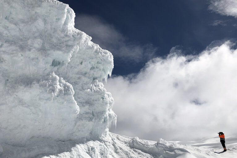 Man photographing a uniquely shaped ice formation
