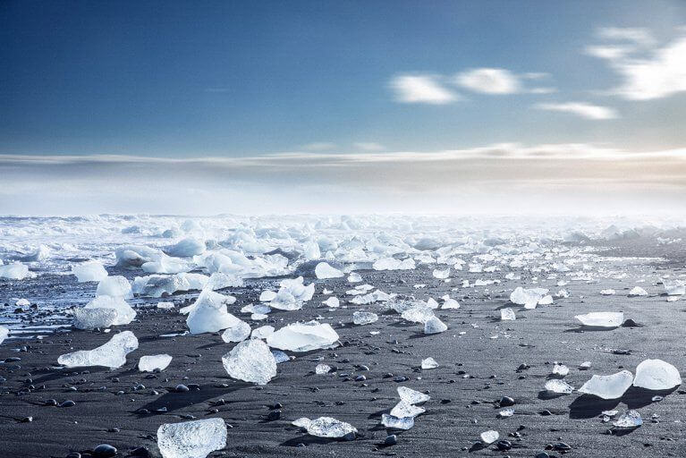 Icebergs washed up on a black sand beach during winter in Iceland