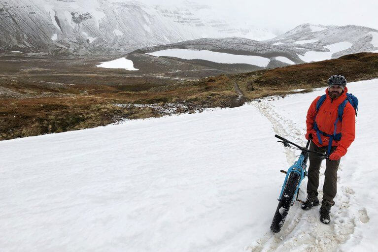 Man smiling during a biking excursion across snowy terrain