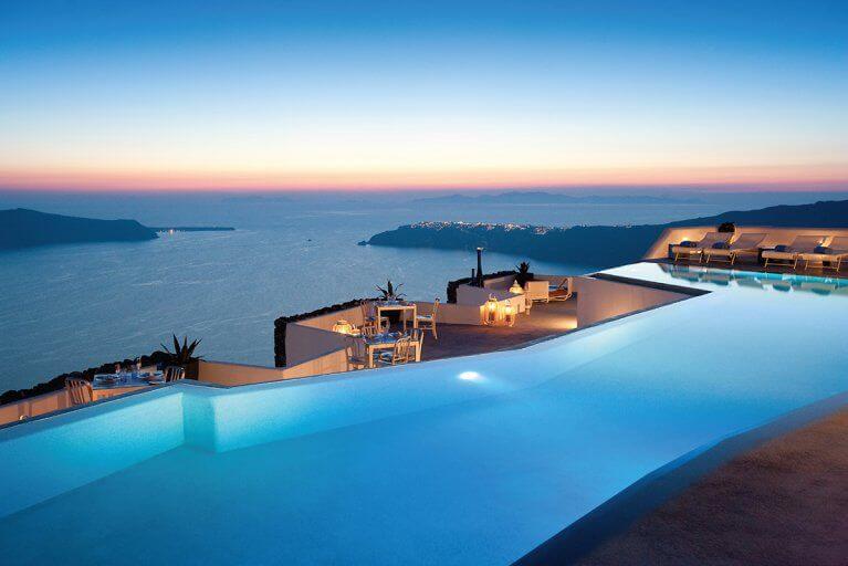 Outdoor infinity pool at luxury Grace hotel at dusk with view of the Aegean Sea