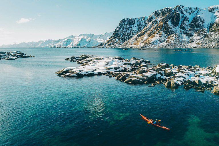 Winter kayaking excursion near snowy mountains in Lofoten