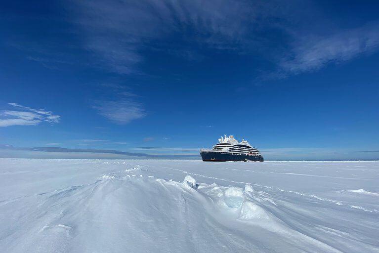 Luxury cruiseship breaking through ice in Antarctica prior to an excursion
