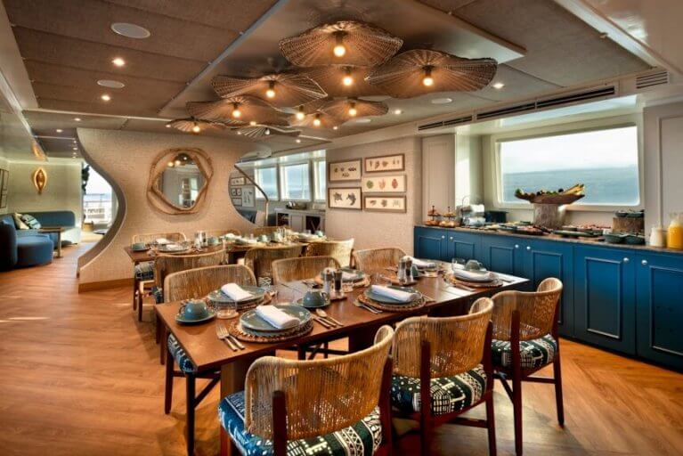 Spacious living room with two sofas and large TV on private luxury yacht cruising in Galapagos Islands