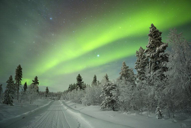 Wintery landscape with the Aurora Borealis at night