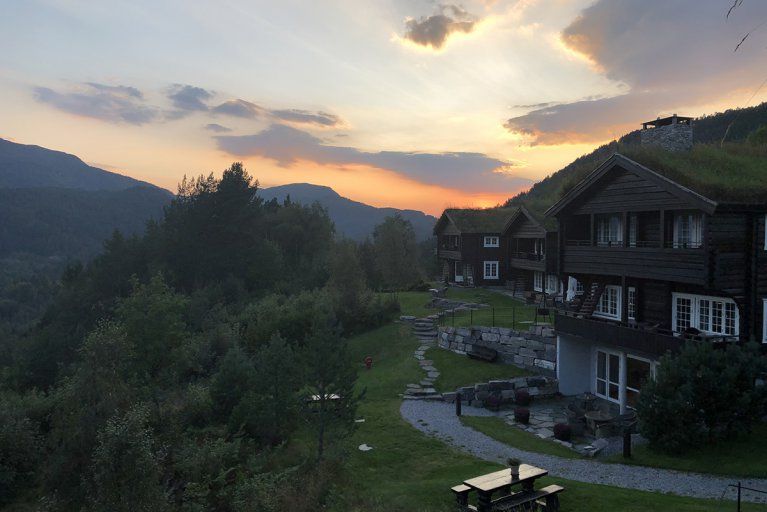 The sun sets behind a wilderness lodge in rural Norway