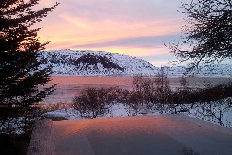 Outdoor hot tub with views over an icy lake and snowy mountains