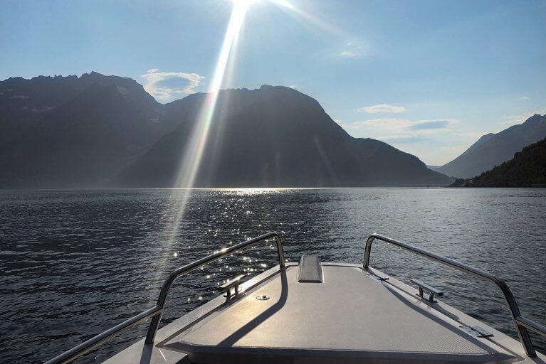View looking out over the bow of a private boat during an excursion in the fjords