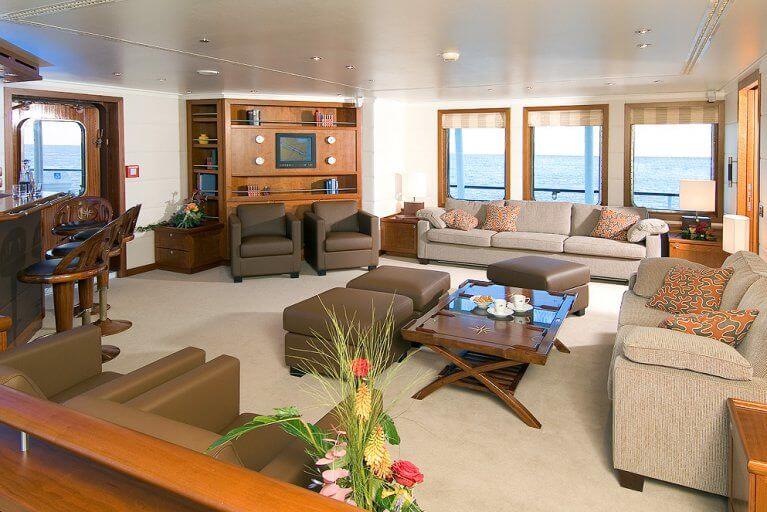 Interior view of the couches and bar of the saloon on the private yacht available for charter in Antarctica