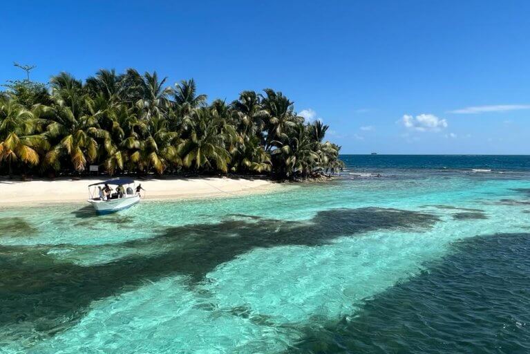 Private boat in crystal blue waters around private island in Belize