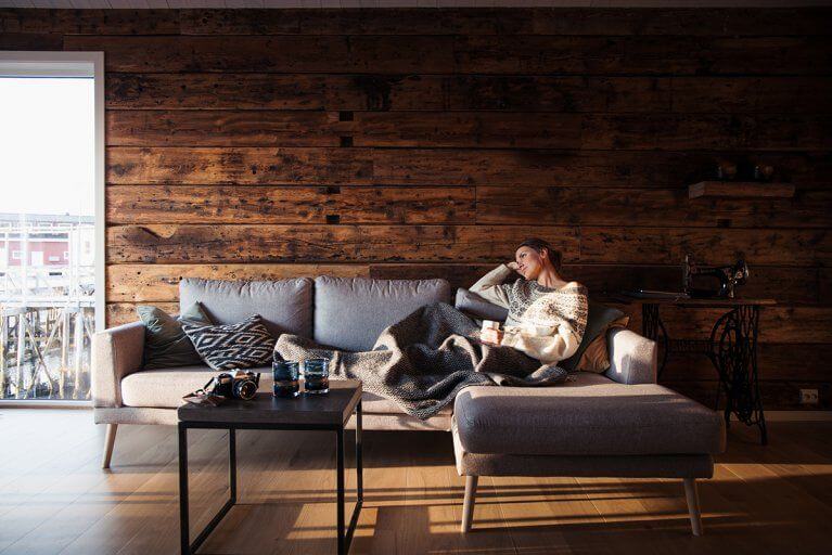 Woman relaxing on a sofa in Hattvika Lodge