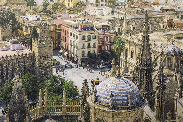 View of white and blue tiled dome and buildings from window of Seville Cathedral