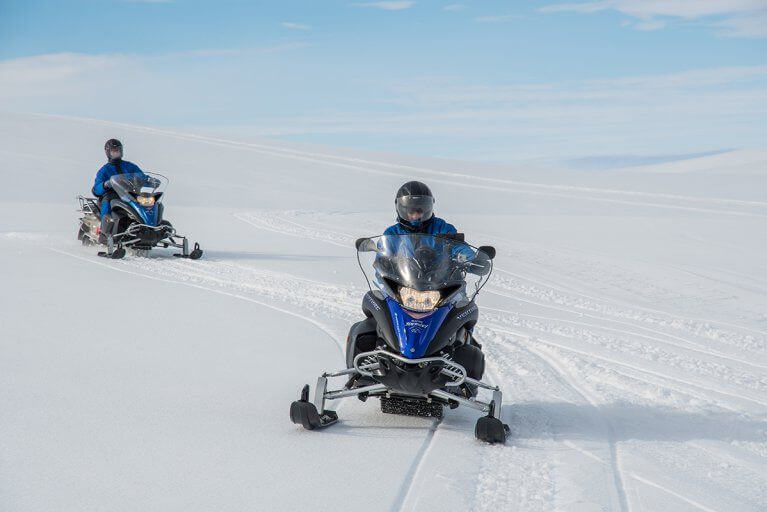 Private snowmobiling excursion across a vast snowy landscape