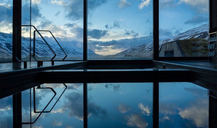Indoor thermal baths with glass windows overlooking mountains in Iceland