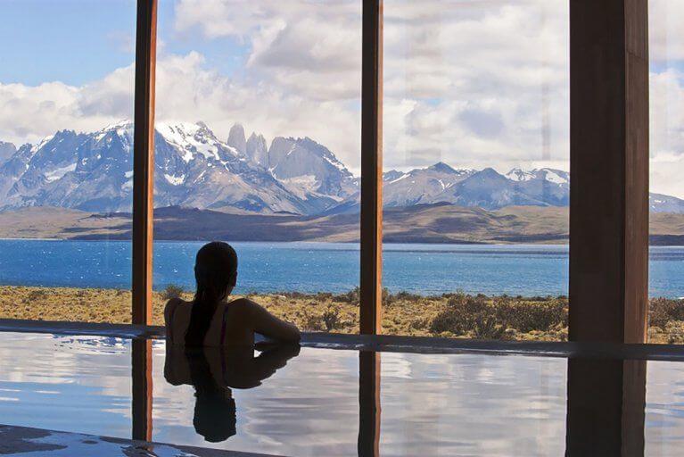 Interior pool of Tierra Patagonia hotel with view of a lake and mountains in Torres del Paine National Park