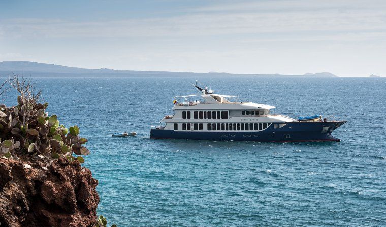 Luxury yacht with dinghy anchored off of Galapagos island