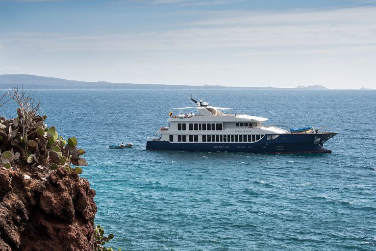 Luxury yacht with dinghy anchored off of Galapagos island