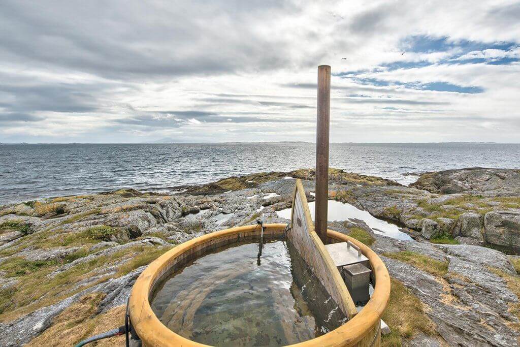 Hot tub perched on a rocky ledge on the Norwegian sea