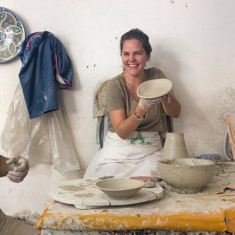Woman shows her handmande wet clay bowl