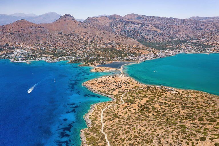 Aerial view of sparkling blue Aegean Sea and town of Elounda in Crete
