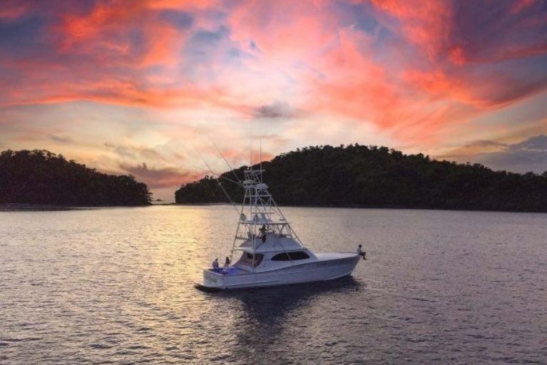 Small boat floating in front of sunset near Islas Secas in Panama