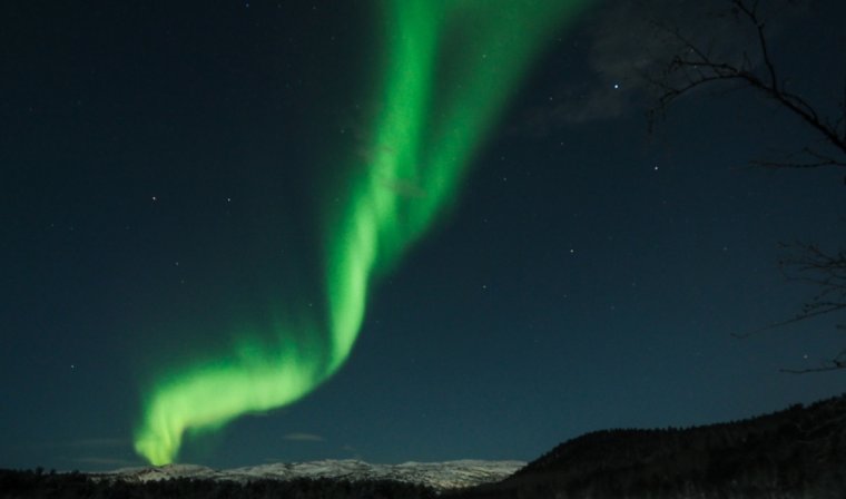 Green flashes of the northern lights above Arctic landscapes in Alta in Northern Norway