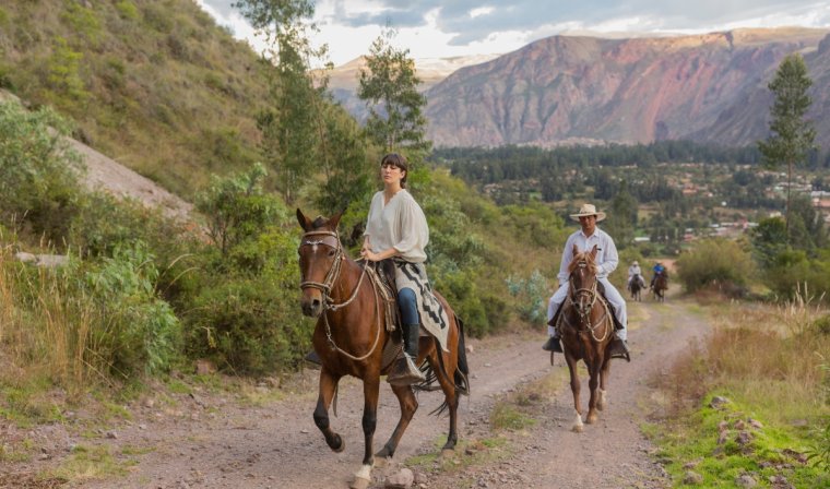 Two people horseback riding through the Sacred Valley during luxury tour of Peru
