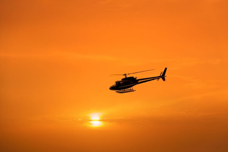 A helicopter flying at sunset.