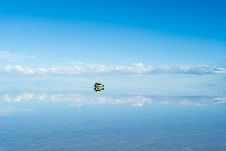 A car driving across the salt flats in Bolivia
