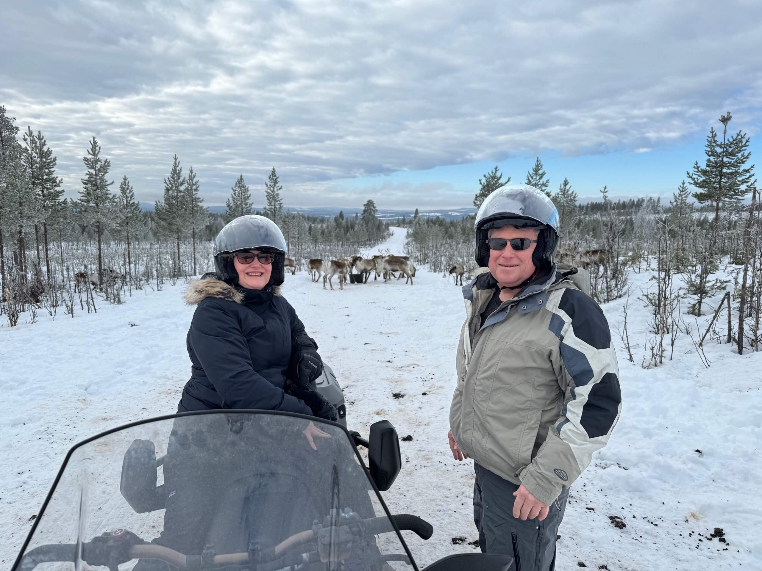 Two luxury travelers enjoying a private snowmobiling excursion in Swedish Lapland